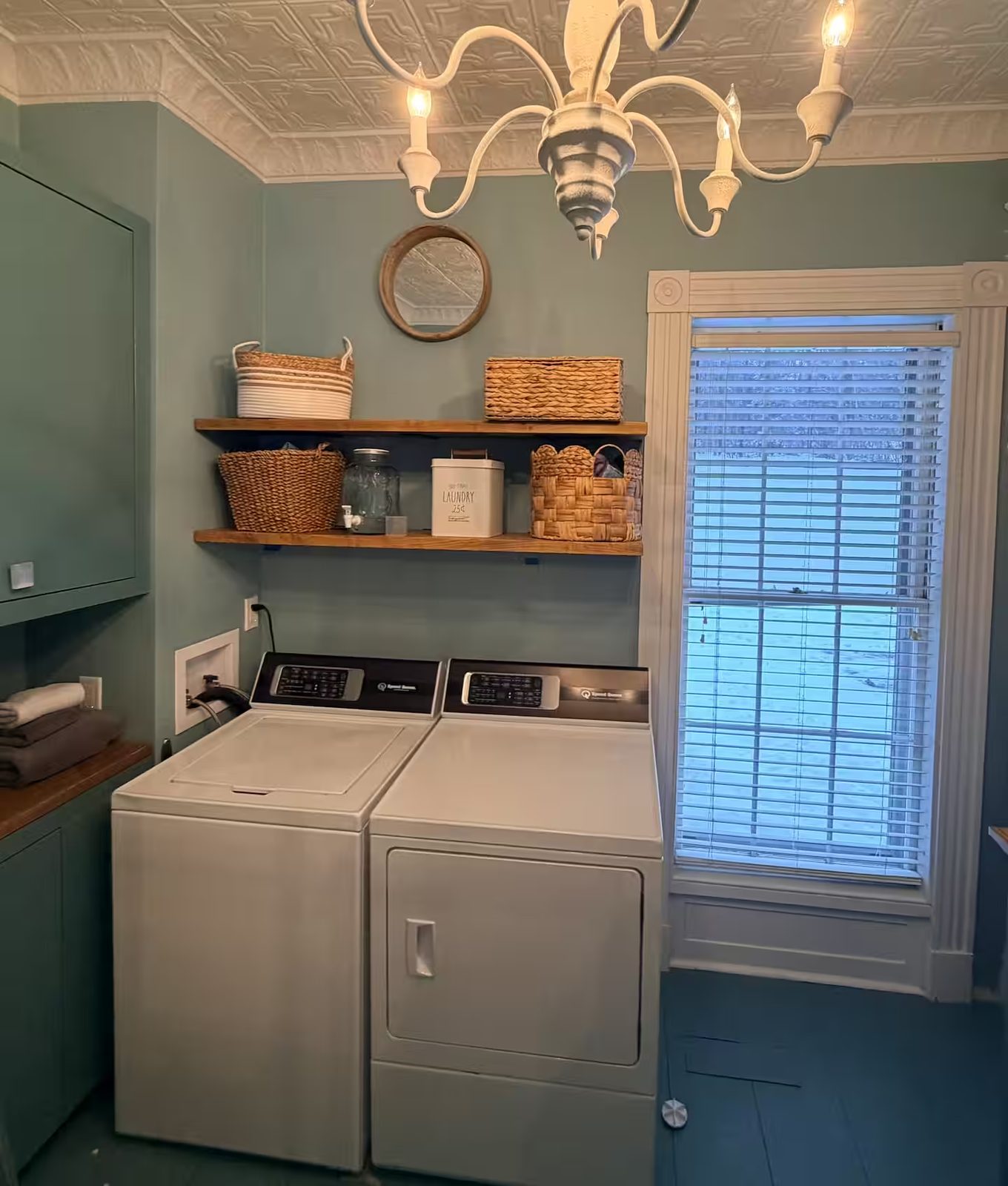 Laundry room with washer, dryer, and chandelier